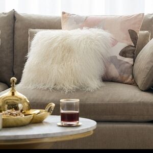 West Elm Mongolian Lamb Pillow Cover on a feather down insert.